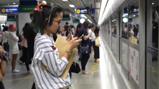 Ásia teen menina usando celular no metrô plataforma esperando para trem . — Vídeo de Stock