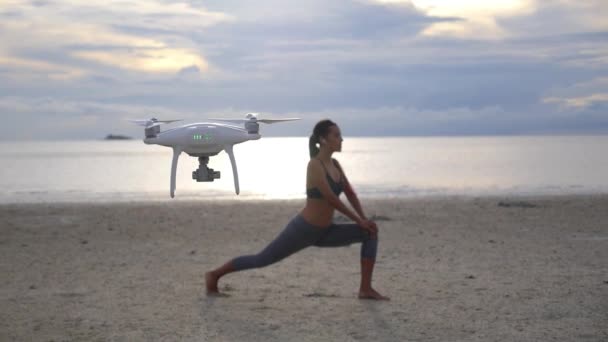 Drone vliegen op het strand en schieten sport vrouw jogger doet oefeningen — Stockvideo