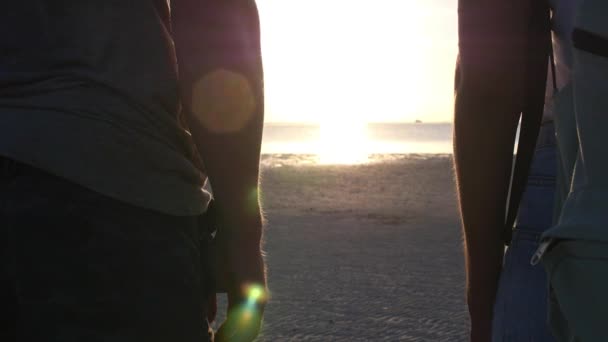 Gün batımında deniz kenarında el ele tutuşan çiftin yakın çekimi — Stok video
