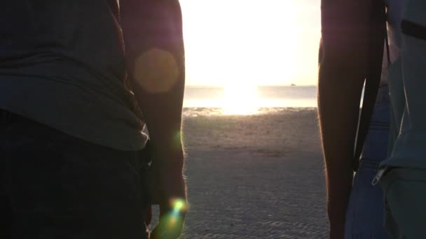 Närbild av par som håller händer vid solnedgången vid havet — Stockvideo