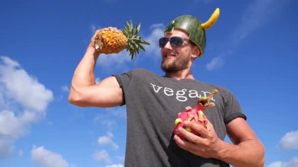 Vegan Power Healthy Lifestyle Concept. Atletische man met fruit tegen de blauwe lucht — Stockvideo