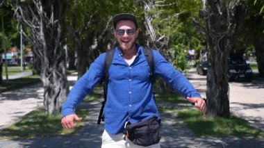 Sırt çantalı Mutlu Gezgin Başparmaklarını Gösteriyor