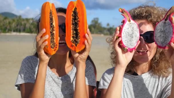 Glückliche junge Freunde mit exotischen Früchten entspannen sich am Strand — Stockvideo