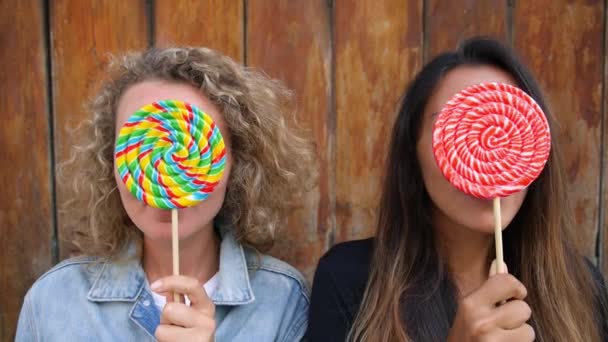 Felices amigas divirtiéndose con caramelos coloridos de piruleta en verano — Vídeos de Stock