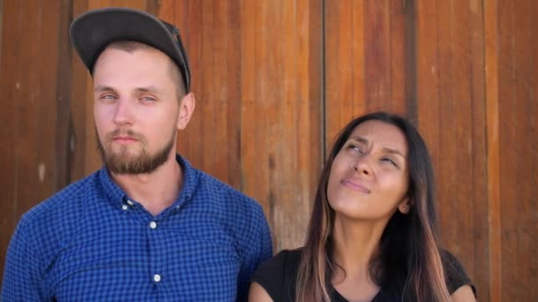 Porträt eines jungen lustigen Paares vor hölzernem Hintergrund — Stockvideo