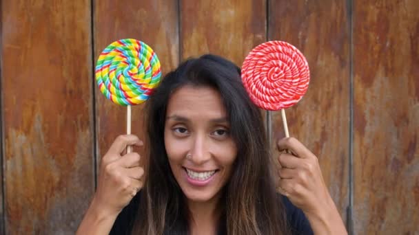 Mujer joven con piruletas haciendo orejas de ratón de Minnie de caramelos — Vídeos de Stock