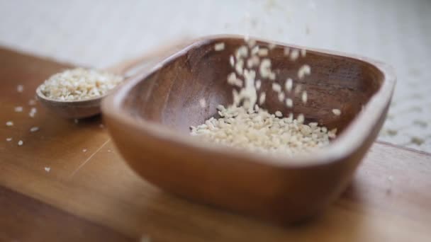 Concepto de comida saludable. Sésamo blanco en tazón de madera. Primer plano. . — Vídeo de stock