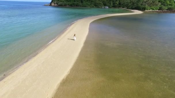 Romantická nevěsta dívka v bílých svatební šaty chůze na pláži. Letecký pohled. — Stock video