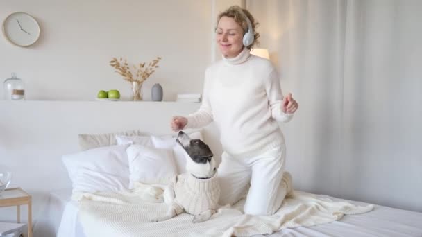 Gravid kvinna dansar och leker med hund hemma — Stockvideo