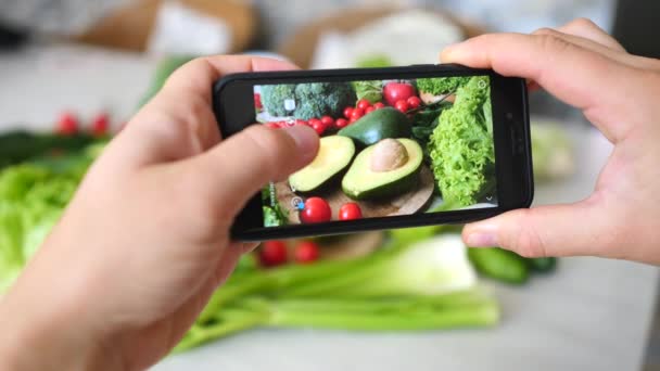 Kvinnliga händer tar foto av hälsosam ekologisk mat på bordet med telefon. — Stockvideo