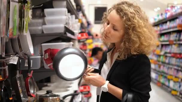 Femme faisant du shopping au supermarché Choisir une poêle — Video