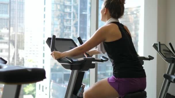 Young Woman at the Gym Cycling on Bike — Stock Video