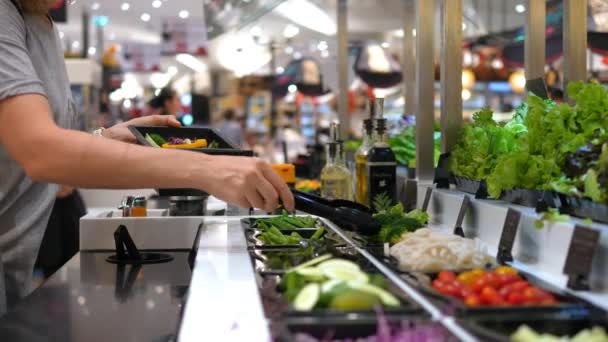 Kadın müşteri süpermarketteki salata barında salata seçiyor. — Stok video