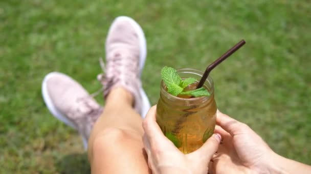 Mujer relajante al aire libre con té helado de menta fresca en verano — Vídeos de Stock