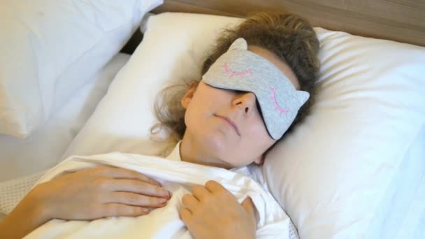 Kvinna i sängen i sovande mask — Stockvideo