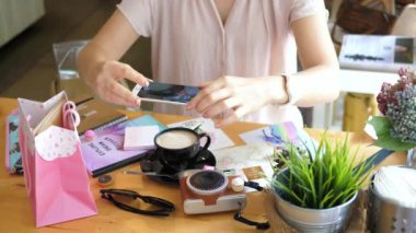 Kadın, kahve ve kamerayla şık bir şekilde yatarken fotoğraf çekiyor.