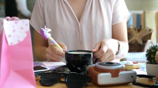 Vrouwelijke handen met Eenhoorn Pen Writing Note met Morning Coffee — Stockvideo