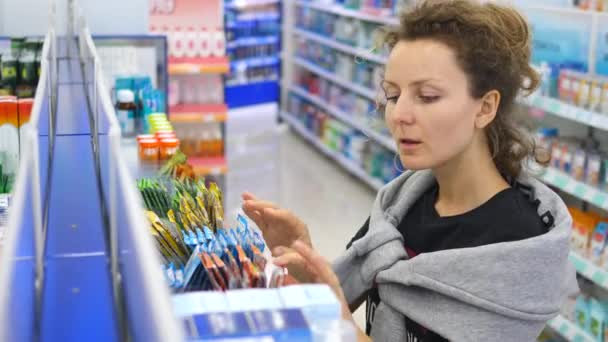 Mujer enferma eligiendo medicina en farmacia — Vídeo de stock