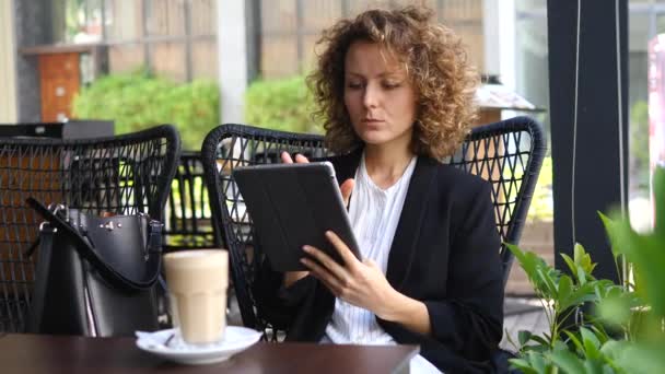 Joven mujer de negocios en una pausa para el café usando tableta — Vídeo de stock