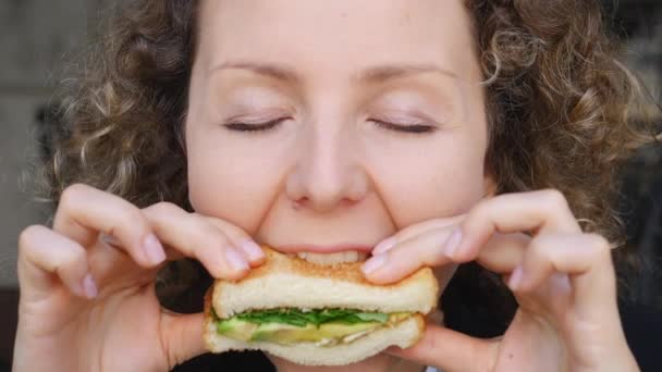 Girl Bites Off Veggie Avocado Sandwich — Stock video