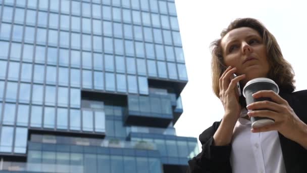 Zakelijke vrouw praten op mobiele telefoon met koffie buiten — Stockvideo