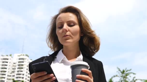 Νεαρή γυναίκα των επιχειρήσεων χρησιμοποιώντας Smartphone σε ένα διάλειμμα για καφέ. — Αρχείο Βίντεο