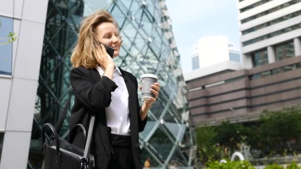 Feliz empresaria teniendo una llamada de negocios con café en las manos — Vídeos de Stock