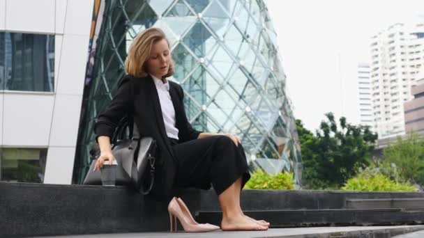 Mujer de negocios feliz quitándose los zapatos y descansando con café al aire libre — Vídeos de Stock