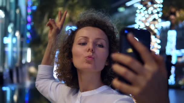 Mladá žena se Selfie s chytrým telefonem v noci v osvětleném městě — Stock video