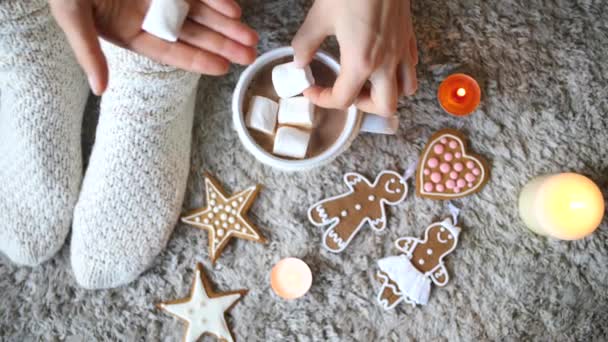 Frauenfüße in gestrickten warmen Socken und Tasse mit heißer Schokolade und Marshmallows. — Stockvideo