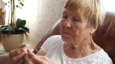 Kıdemli Kadın İşitme Cihazı Tutuyor.