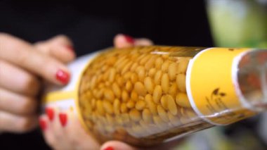 Süpermarkette soya fasulyesi ezmeli cam şişe yakın plan. Etiket Okuma ve İçindekiler Denetleniyor.