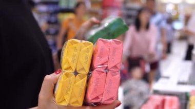 Kadın müşteri süpermarketten hijyen ürünleri alıyor.