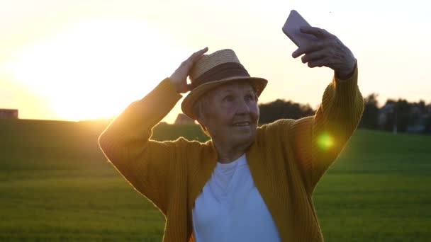 Hip Grandma Taking Selfie In Straw Hat With Smartphone At Sunset — Stock Video