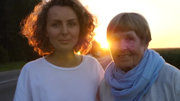 Portret babci z wnuczką na zewnątrz o zachodzie słońca — Wideo stockowe