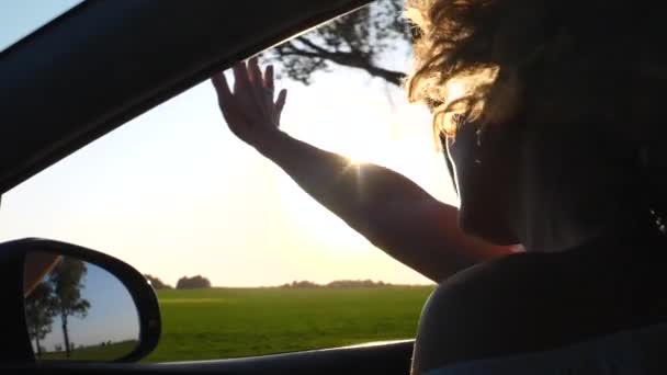 Mulher dirigindo no carro ao pôr do sol — Vídeo de Stock