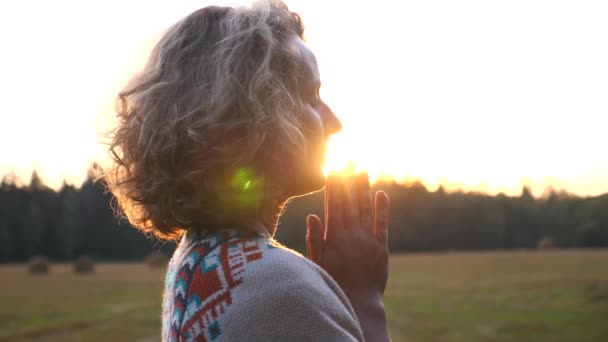 Ung kvinna som ber, utövar yoga och meditation vid solnedgången — Stockvideo