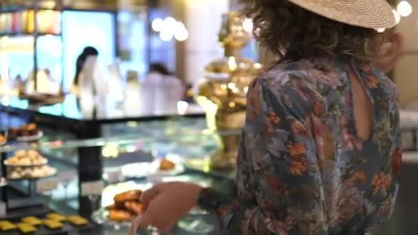Mujer eligiendo pastel mirando vitrina con pastelería en restaurante o pastelería — Vídeos de Stock