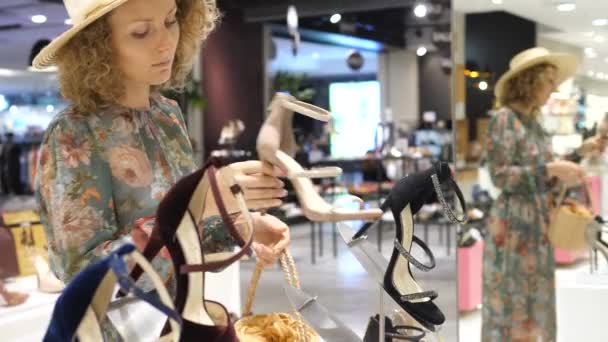 Молодая женщина покупает обувь в магазине — стоковое видео