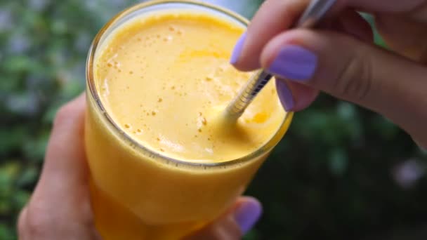 Primer plano de manos femeninas sosteniendo jugo de naranja fresco. Concepto de estilo de vida saludable . — Vídeos de Stock