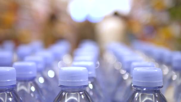 Κοντινό πλάνο για το πόσιμο νερό μπουκάλια σε ακατέργαστο και γραμμές στο σούπερ μάρκετ — Αρχείο Βίντεο