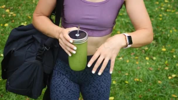 Νεαρό κορίτσι που κρατά πράσινο vegan Smoothie. Γυμναστική και υγιή τρόπο ζωής Concept. — Αρχείο Βίντεο