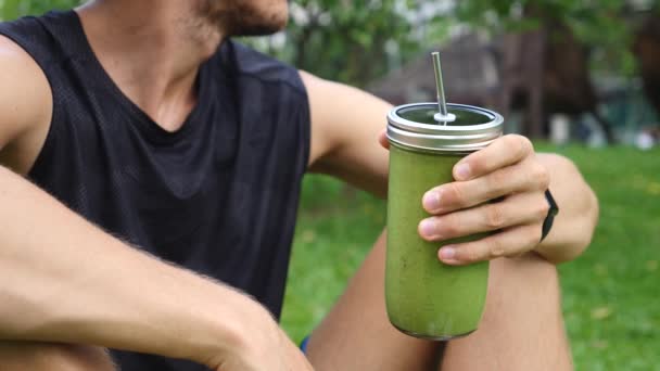 Sportler Mann trinkt grünen Smoothie. Fitness und gesundes Lebensstil-Konzept. — Stockvideo