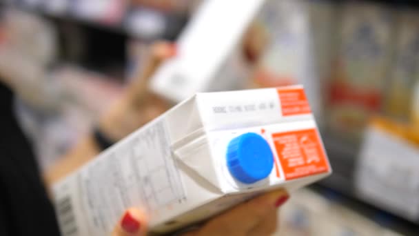 Nahaufnahme einer Kundin, die sich im Supermarkt für Milch entscheidet. — Stockvideo