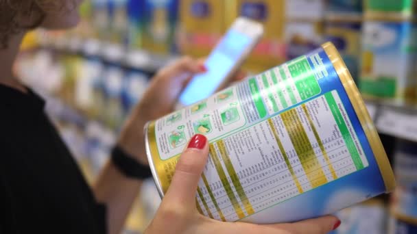 Primer plano de las manos utilizando el teléfono de verificación de ingredientes del producto en el supermercado. BANGKOK, TAILANDIA - 16 DE ABRIL DE 2018 . — Vídeos de Stock