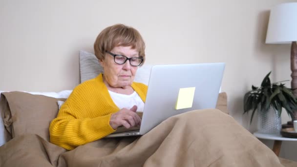 Технологии для пожилых и пожилых людей. Бабушка работает с ноутбуком . — стоковое видео