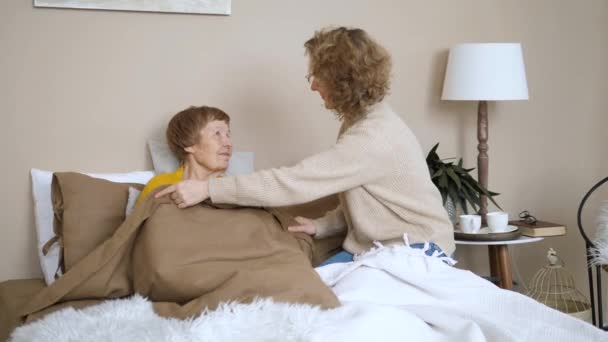 Äldre Vård, Generation, Familjebegreppet. Barnbarn tar hand om mormor i sängen. — Stockvideo