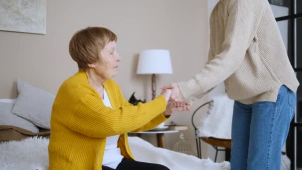 Erwachsene Enkelin umarmt ihre Großmutter. — Stockvideo