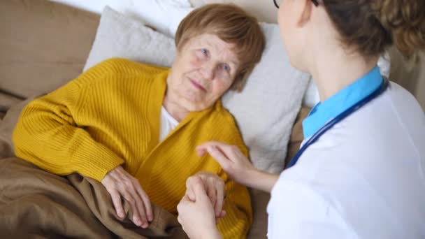 Concept Médecine, âge, soutien, soins de santé et personnes - Médecin ou infirmière acclamant une femme âgée . — Video