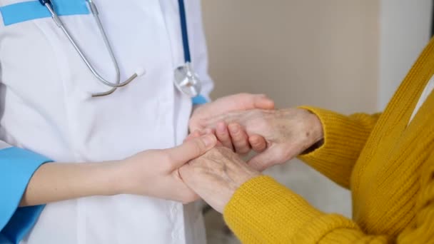 Medico tenendo le mani della donna anziana paziente . — Video Stock